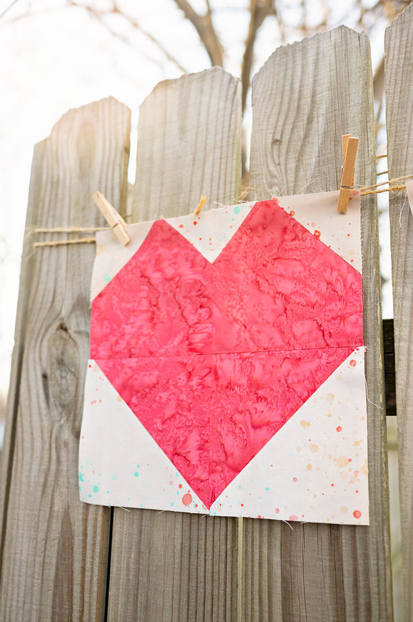 Heart quilt block displayed on a rustic fence