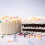 two white chocolate dipped oreos with one cut in half to show the inside