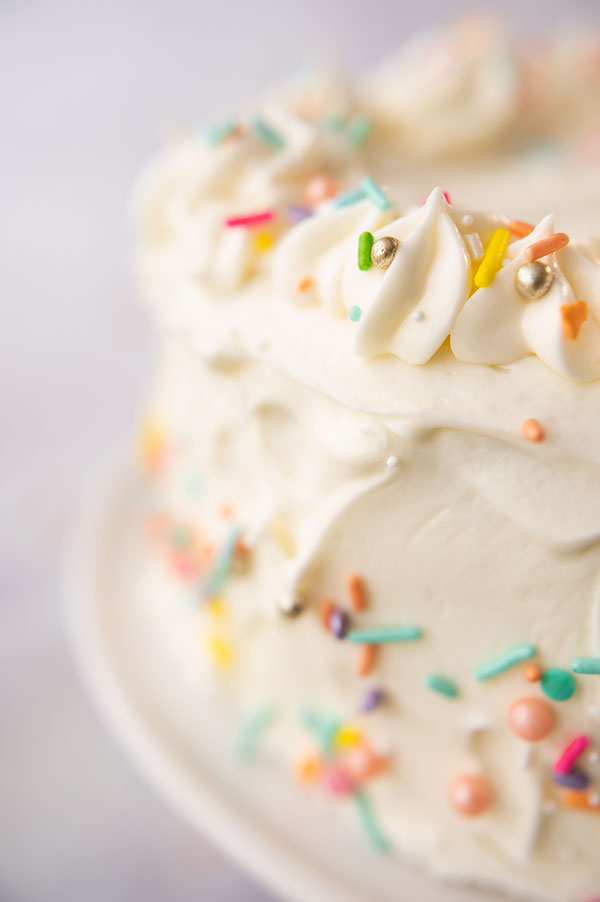 close up of a white cake decorated with colorful sprinkles