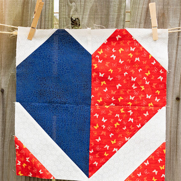 finished quilt block displayed on a rustic fence