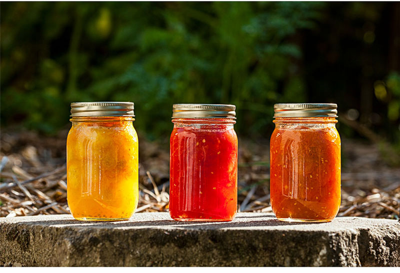 three jars of vibrant canned fruit