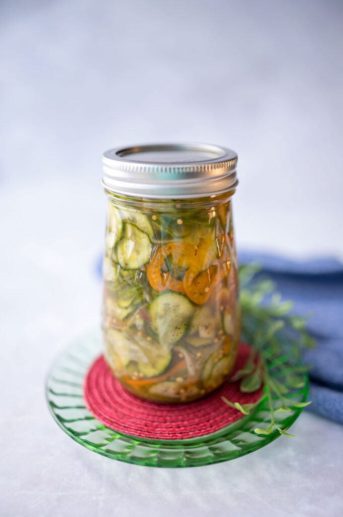 fluted jar contains fresh slices of cucumber and orange bell peppers