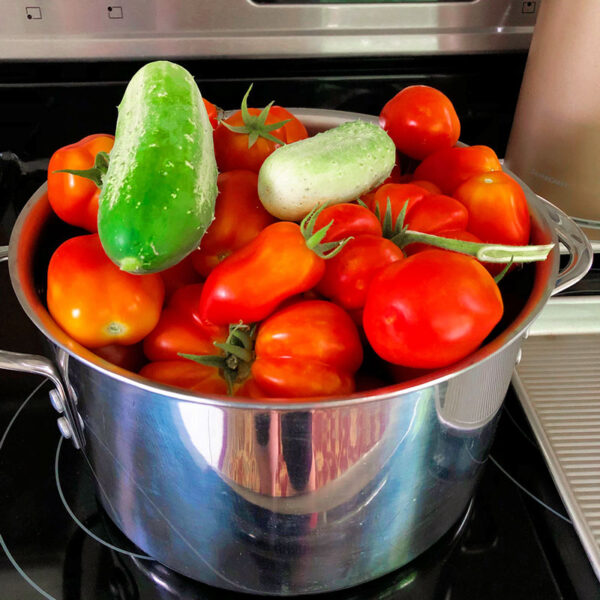 a stainless steel pot full of fresh garden produce