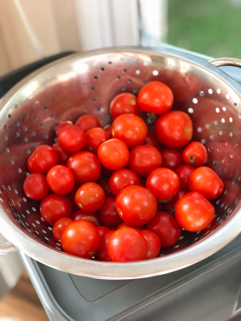 A strainer full of rip cherry tomatoes