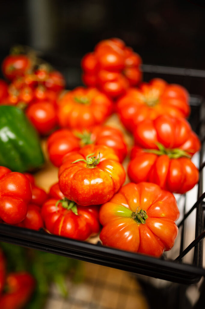 a basket filled with small, fluted orange and red tomatoes