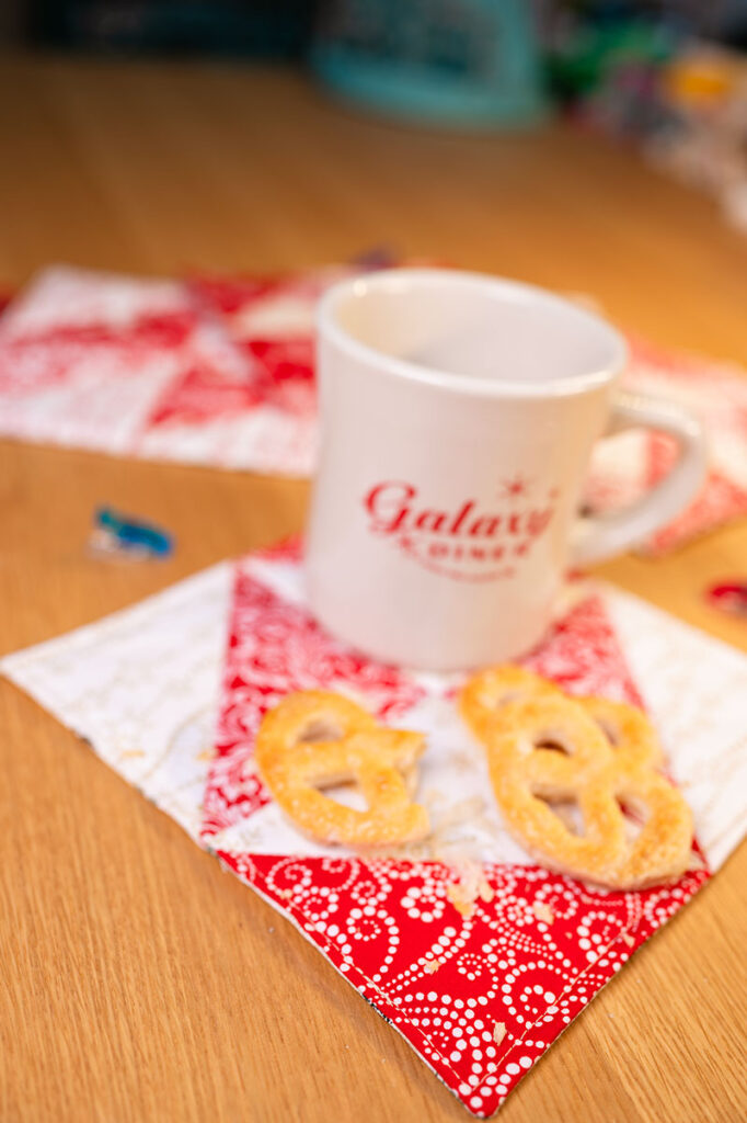 ceramic mug with cookies on a quilted red and white mug rug