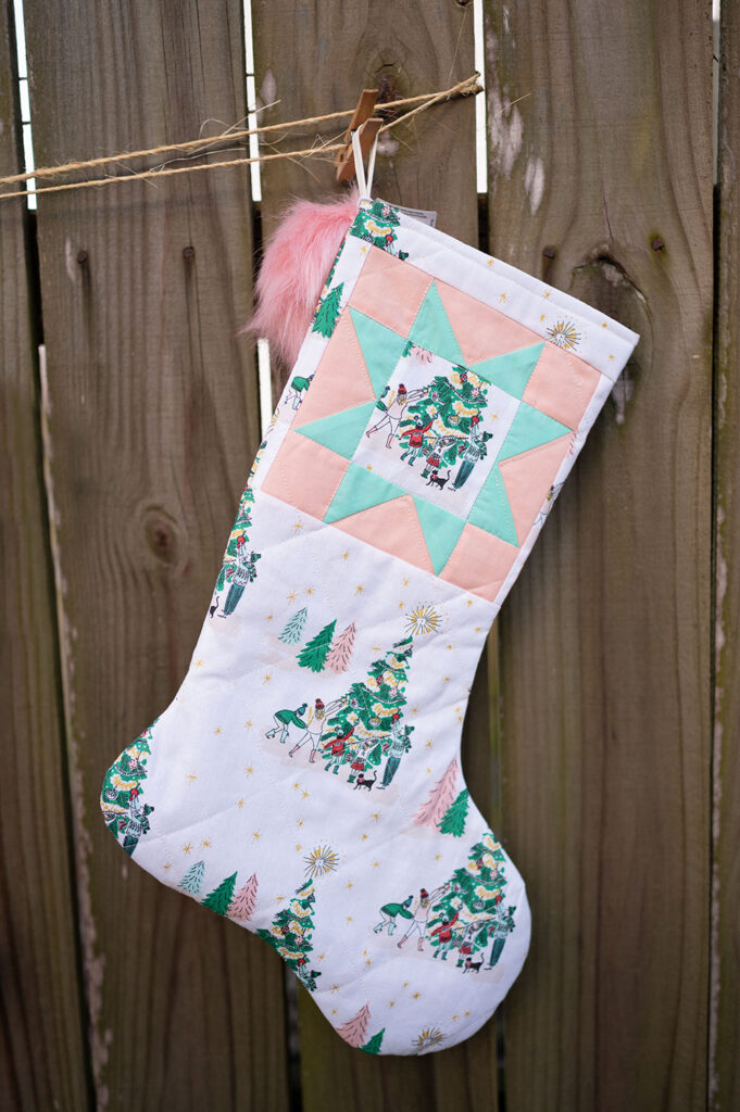 a Christmas stocking made in light fabric with a mint green and baby pink color palette