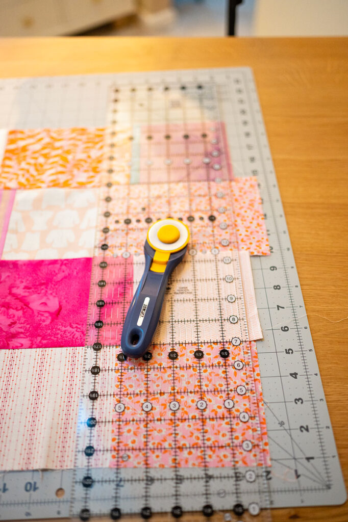 a quilt top ready for trimming with a rotary cutter and ruler