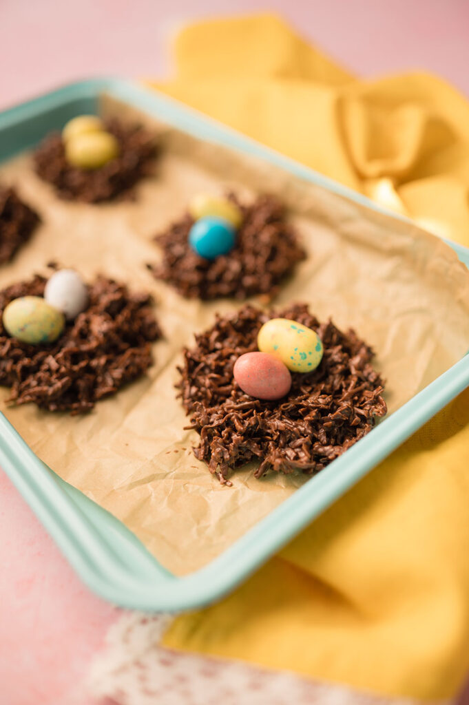 5 cookies made of chocolate and coconut topped with easter eggs