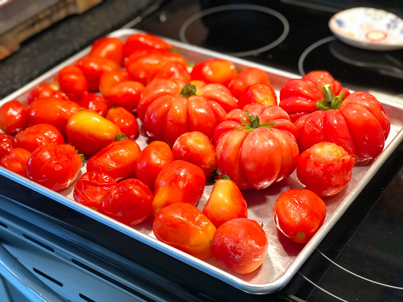 partially frozen tomatoes on a sheet pan