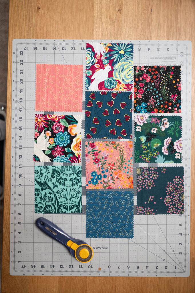 10 fabric squares on a cutting board