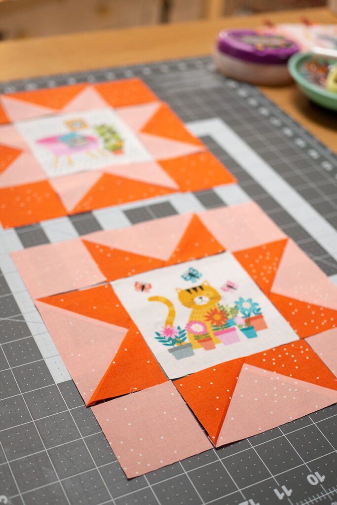 2 sawtooth star quilt blocks featuring center cat illustrated panels
