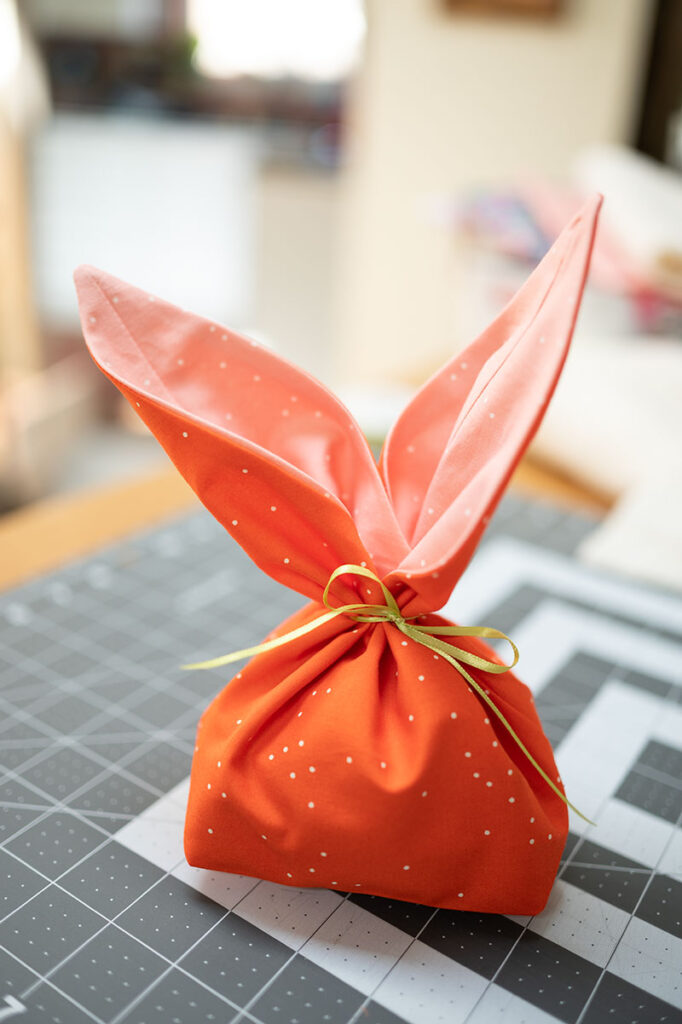 an orange bunny ear bag on a sewing table