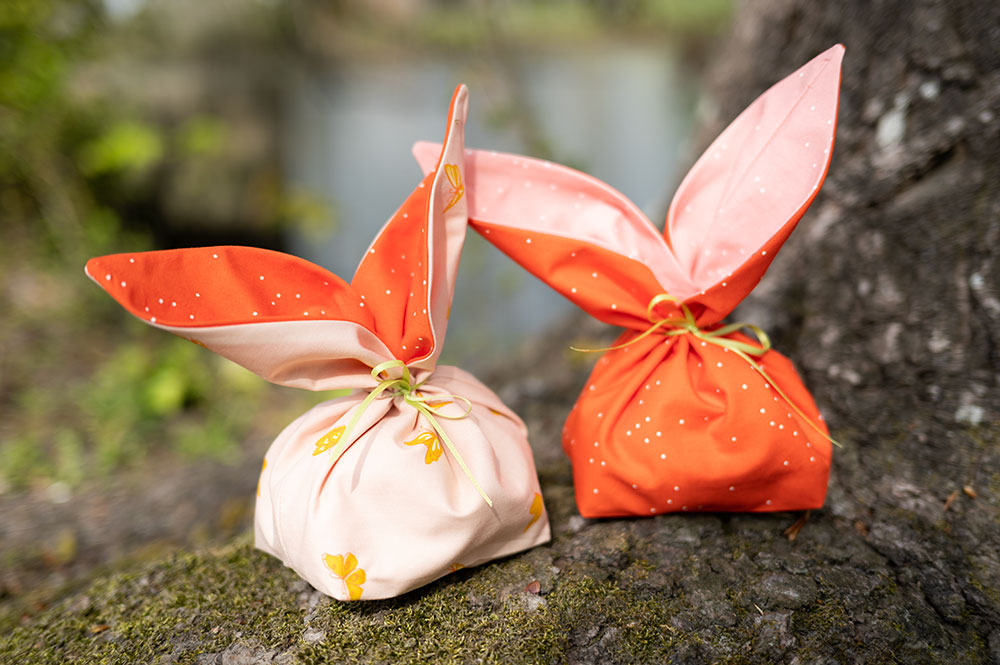 two fabric bunny ear treat bags in pink and orange colors