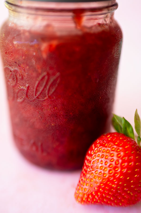 close up of straweberry jam in a glass jar